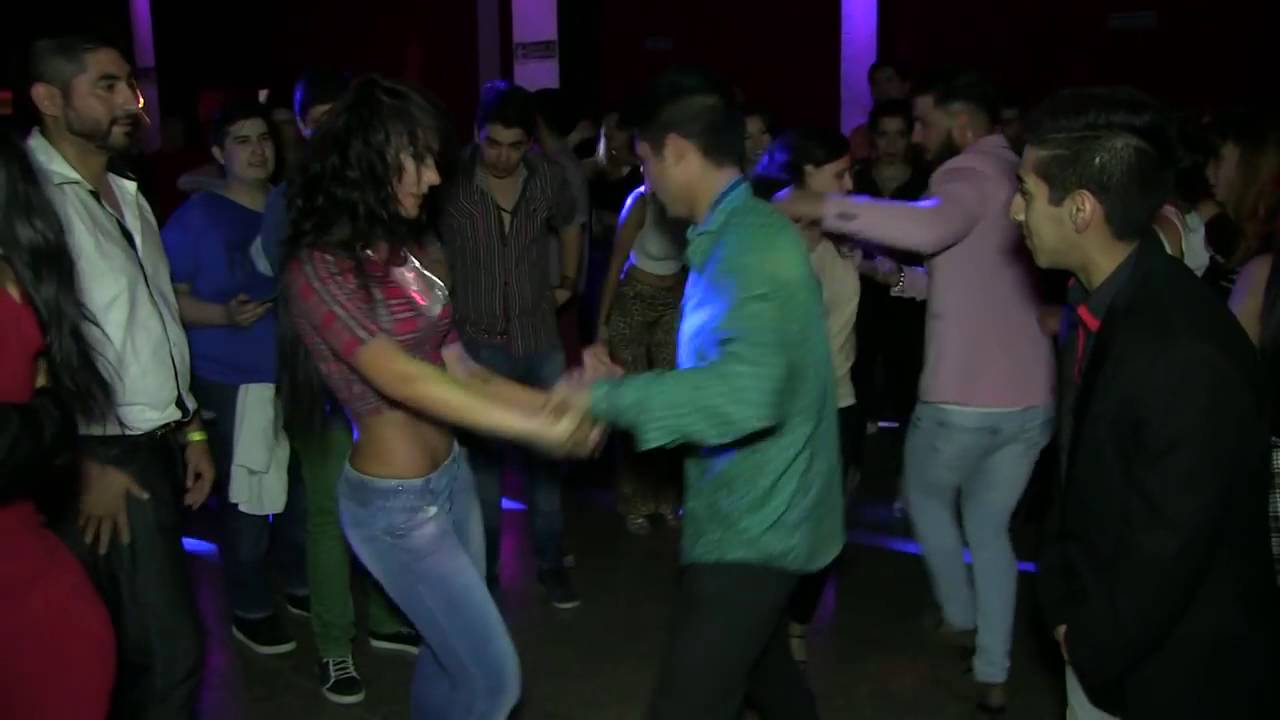 Hermosa chica bailando bachata con varios hombres
