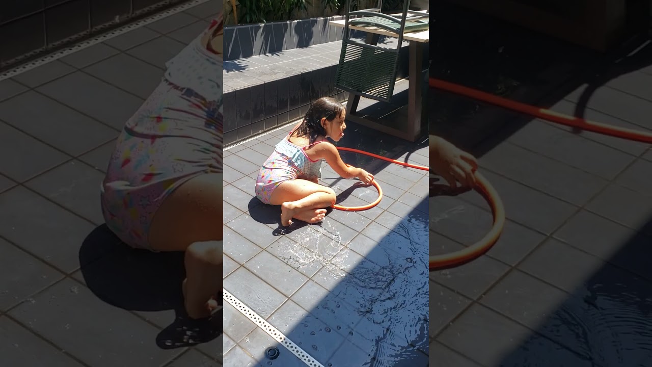 Teodora tomando banho de mangueira